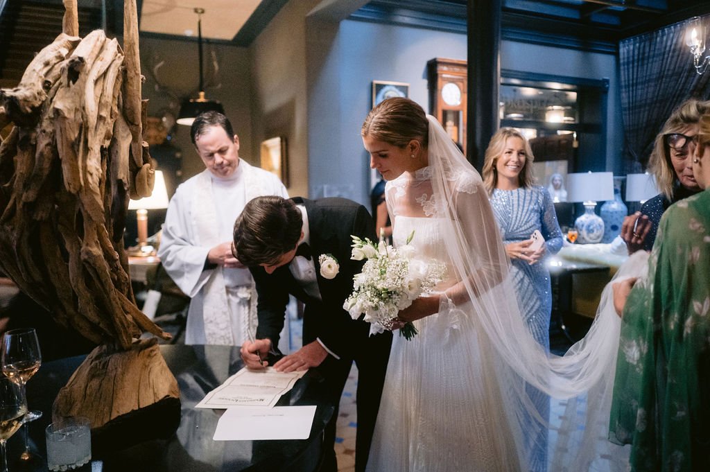 bride and groom signing papers at their wedding venue in aspen