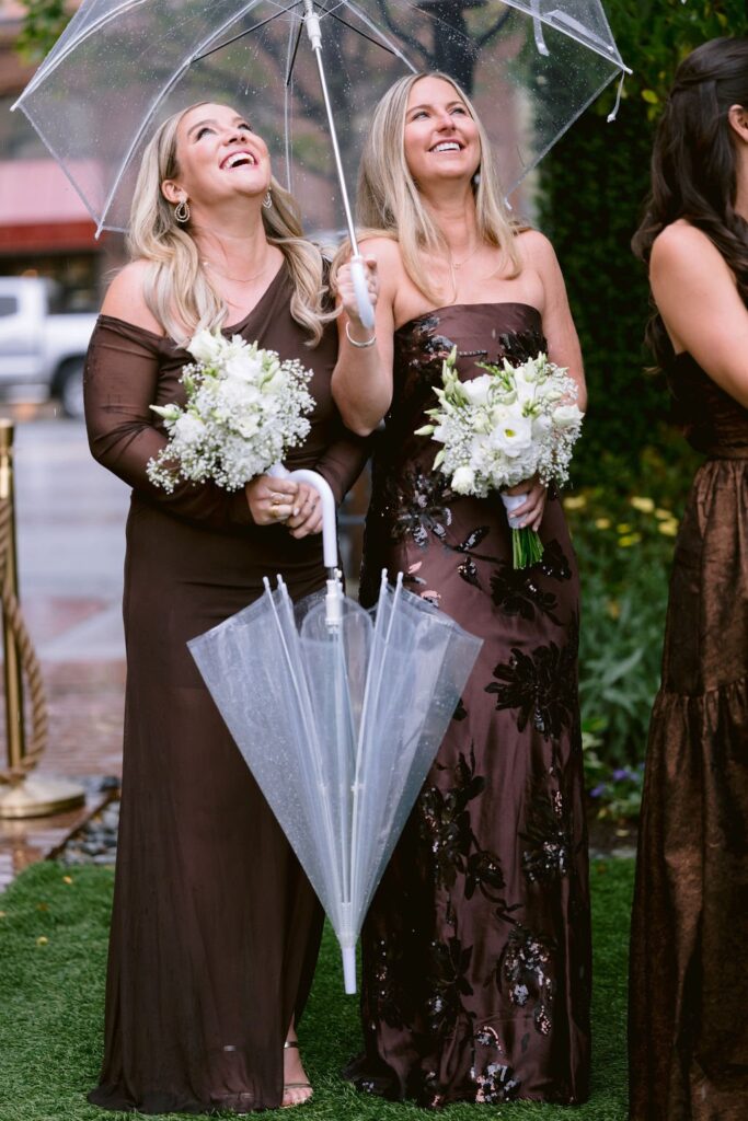 bridesmaids looking up at the rain during a jerome aspen hotel wedding ceremony