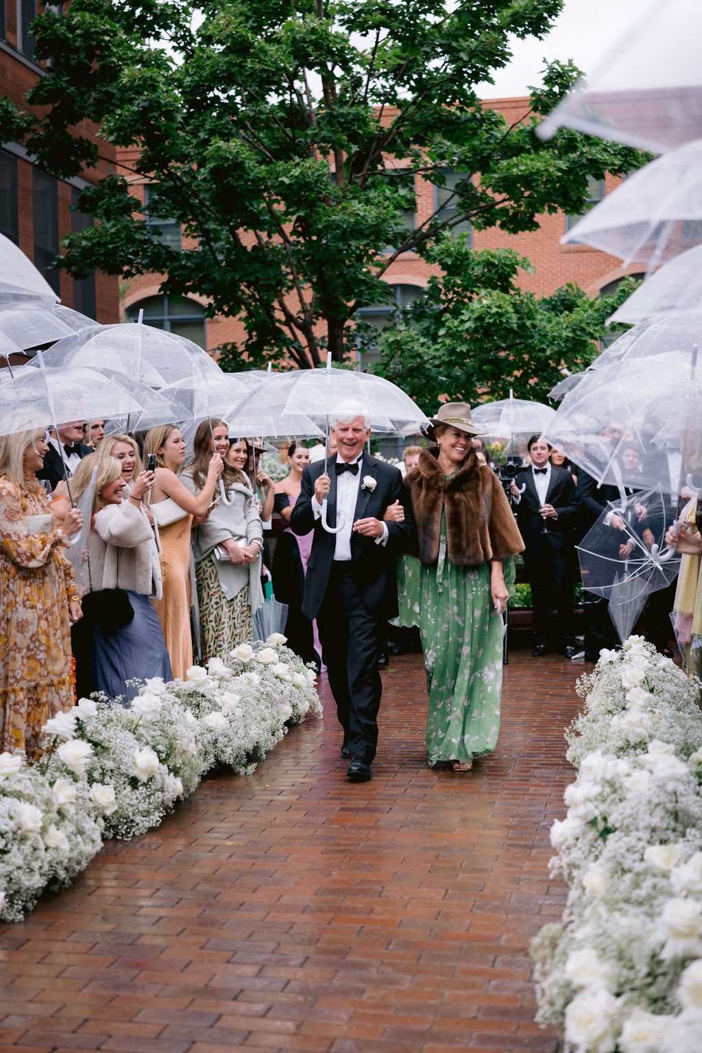 man and women walking down a brick pathway to their spot during a ​aspen jerome hotel wedding ceremony