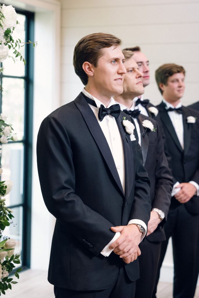 groom watching his bride walk down the aisle during their old edwards in wedding
