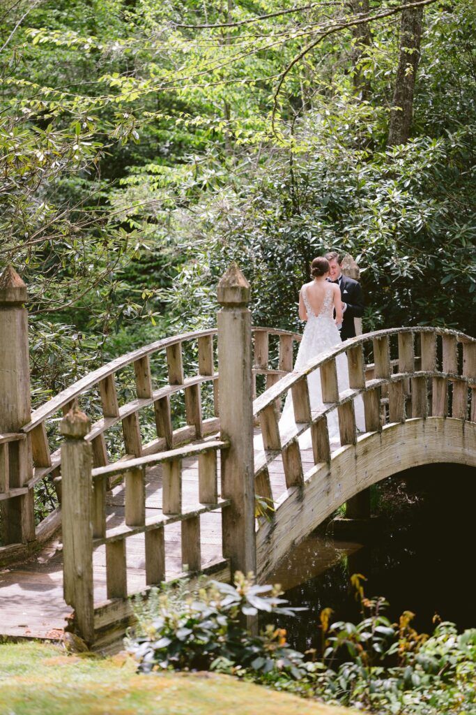 bride and groom share an intimate moment on the small footbridge overlooking the pond at old edwards inn