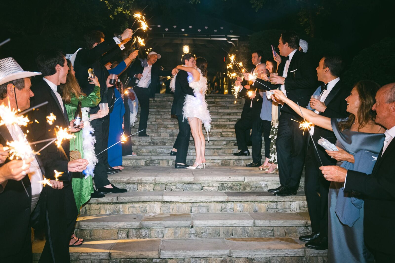 bride and groom standing on step while guests hold up sparkles at the end of their reception during their old edwards inn and spa wedding 