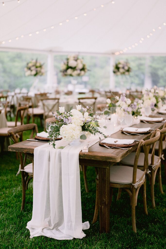 long table stretched across the grass, layered with florals and soft textures at Piermont Cottage at Old Edwards Inn and Spa