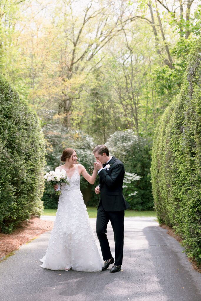 groom kissing bride on her hand while sharing an intimate moment during their portrait shoot at their old edwards inn wedding