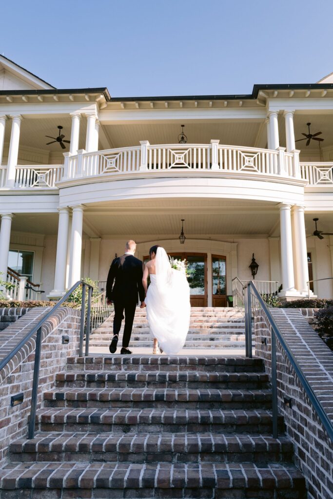 bride and groom walking up brick stairs to enter their sea pines resort wedding reception