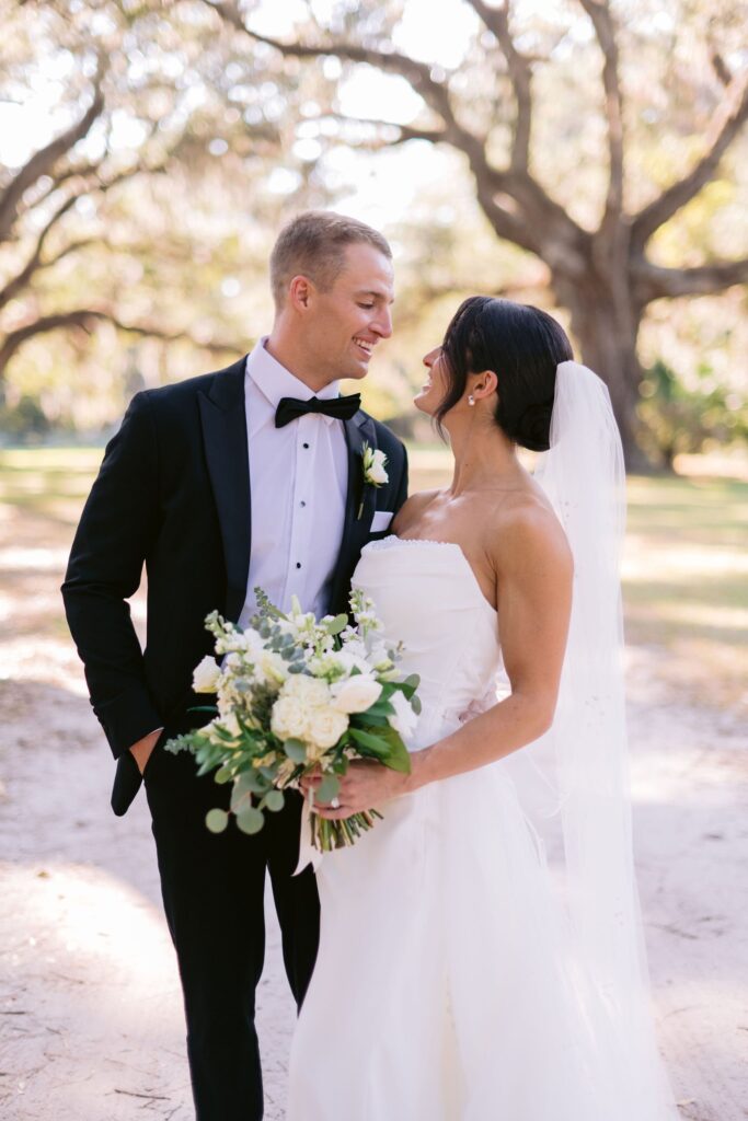 portrait by laura stone photo of bride and groom staring lovingly into each other's eyes  at the Six Oaks Cemetery before their sea pines resort wedding ceremony