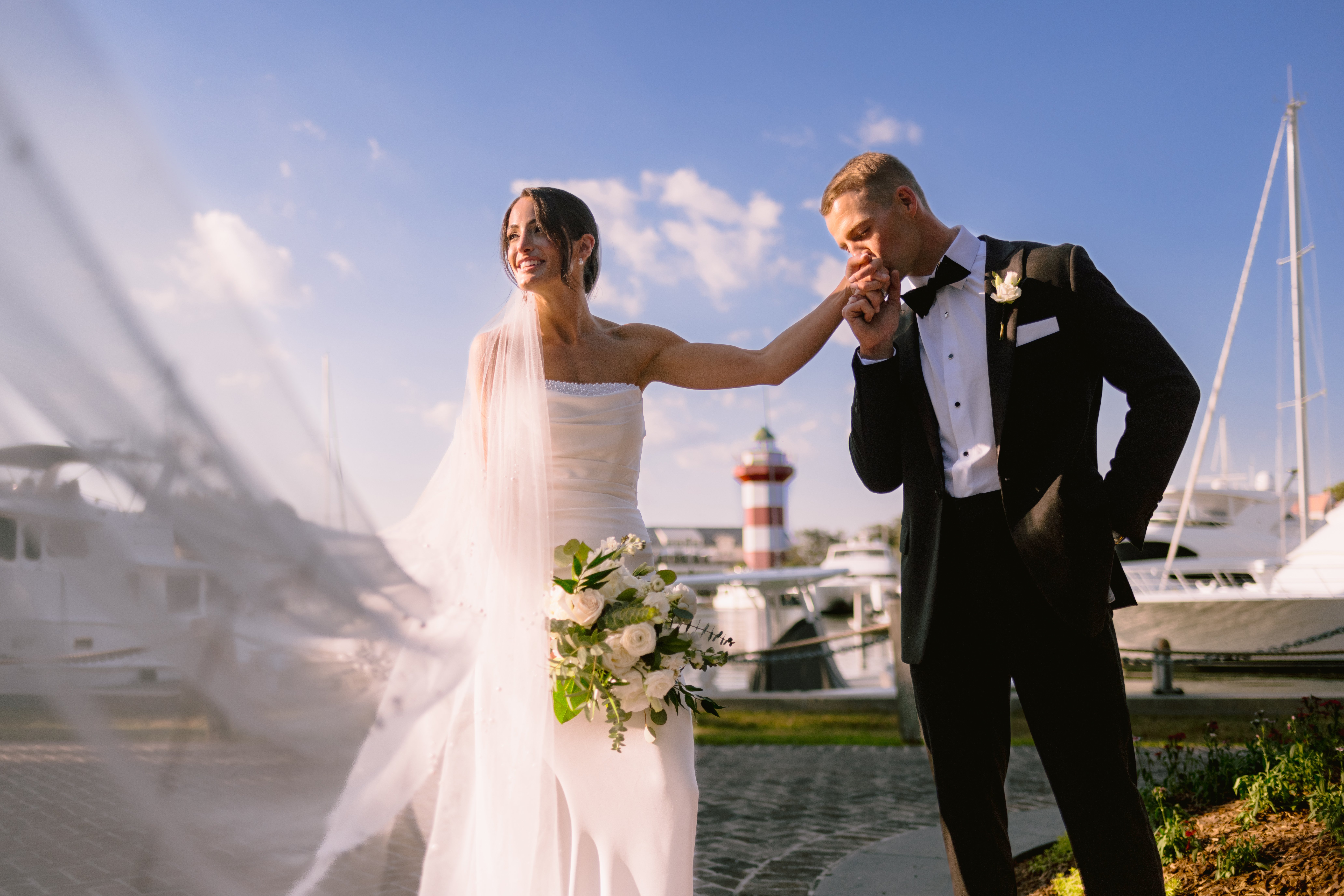 groom kissing bride on her hand during their portrait shoot at their sea pines hilton head wedding