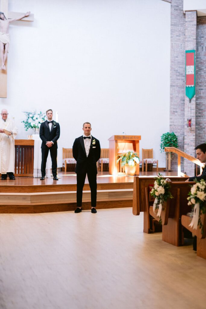 groom standing at the alter waiting for his bride in St. Francis by the Sea Catholic Church during his sea pines
