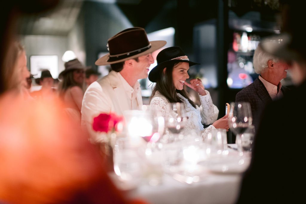 bride and groom at their wedding table while speaches are given at their aspen meadows wedding
