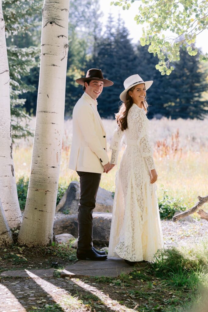 bride and groom looking backwards toward the camera at their aspen meadows wedding portrait sessions