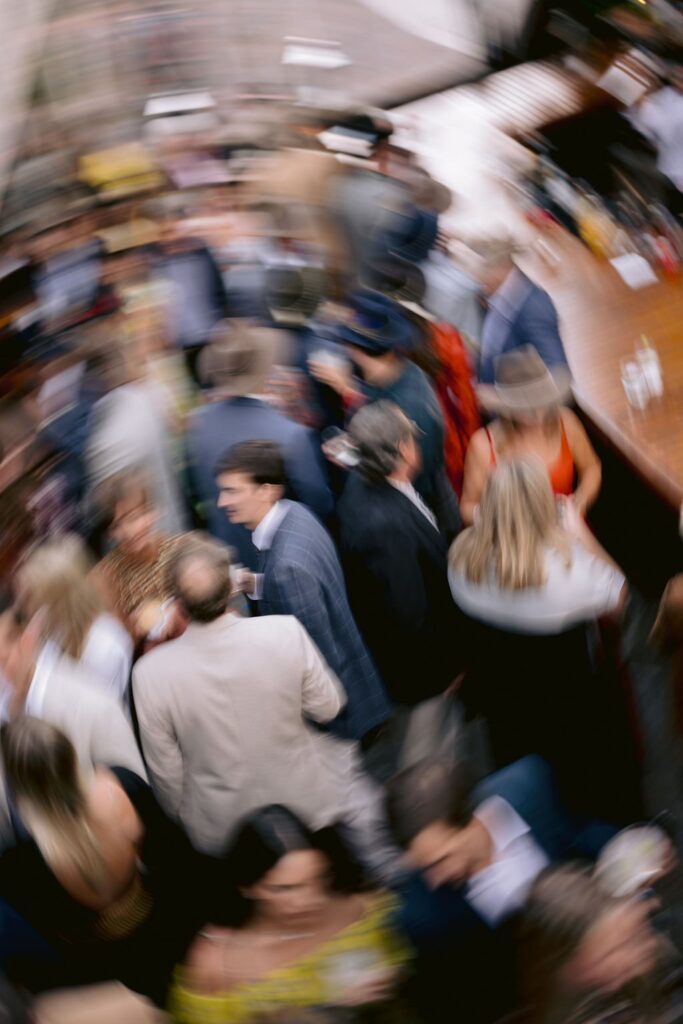 blurry aerial view photo of wedding guests having conversations during an aspen meadows wedding