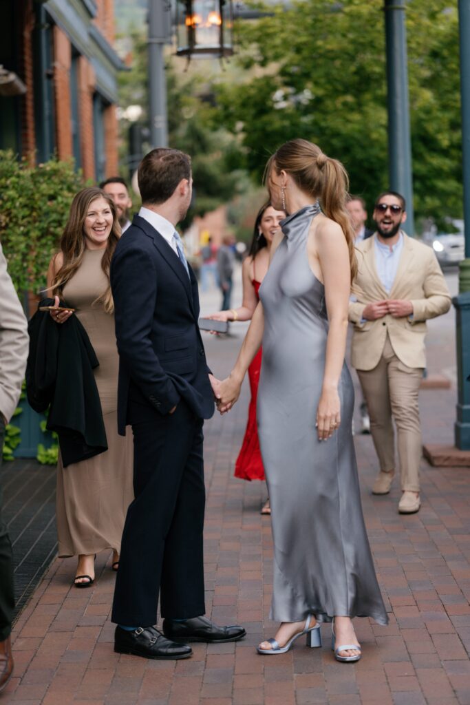 wedding guests arriving in downtown aspen colorado for a luxury wedding in aspen, walking along brick sidewalks near aspen wedding venues