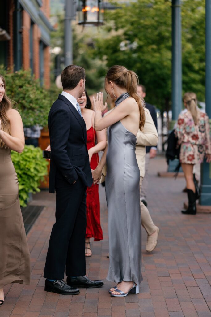 friends greeting each other before an aspen wedding, stylish guests gathering in an ideal location in aspen colorado