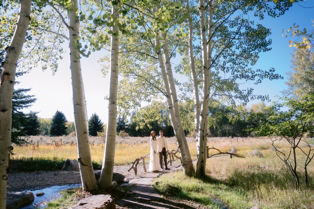 bride and groom standing beneath aspen trees during a luxury wedding in aspen colorado with stunning natural backdrops