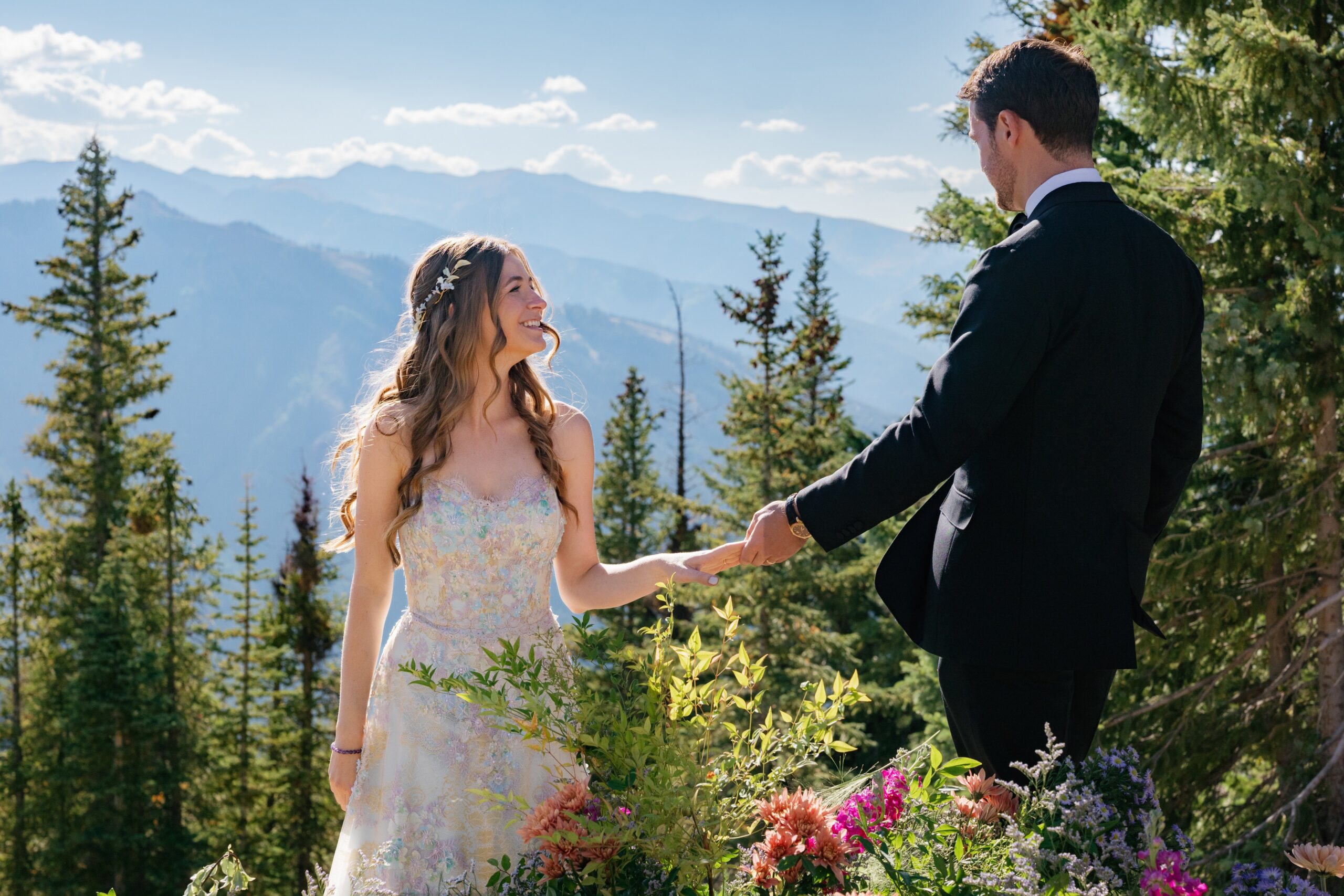 bride and groom holding hands during a luxury wedding in Aspen on aspen mountain with panoramic colorado views and stunning backdrops