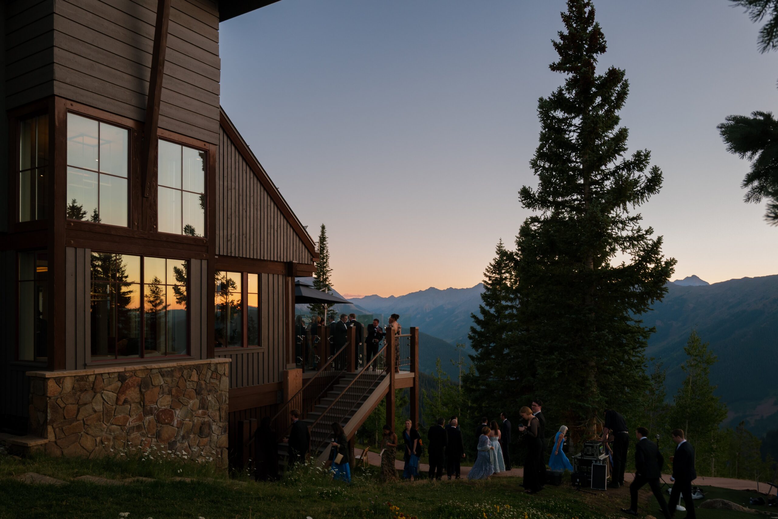 luxury wedding in Aspen at a mountain wedding venue with sunset views and guests gathered on a private deck overlooking the colorado mountains