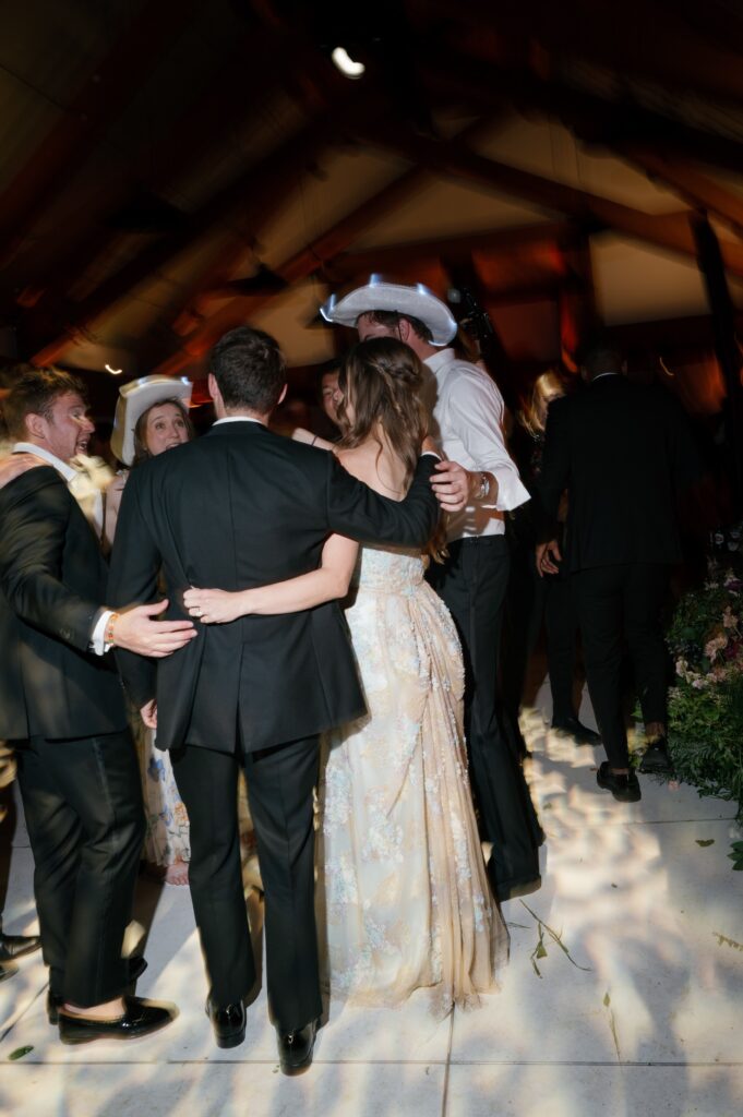 guests dancing at an aspen mountain wedding reception with the bride in a floral gown