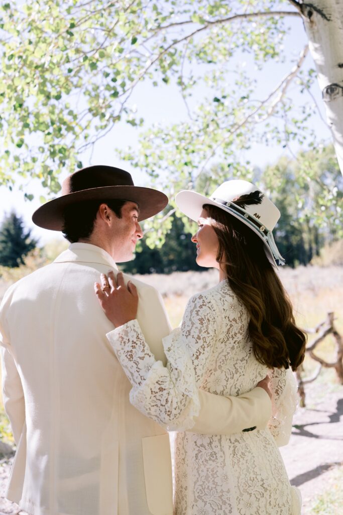 bride and groom embracing under aspen trees during a romantic luxury wedding in aspen
