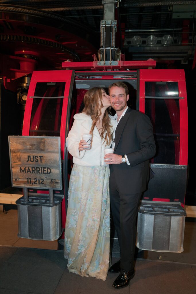 newlyweds posing in a red gondola after their luxury wedding in aspen colorado