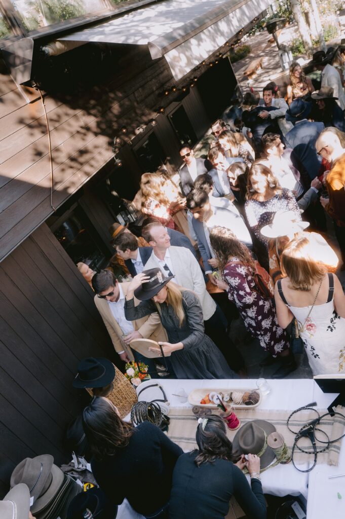 guests enjoying a custom hat fitting experience during a luxury wedding in Aspen, Colorado