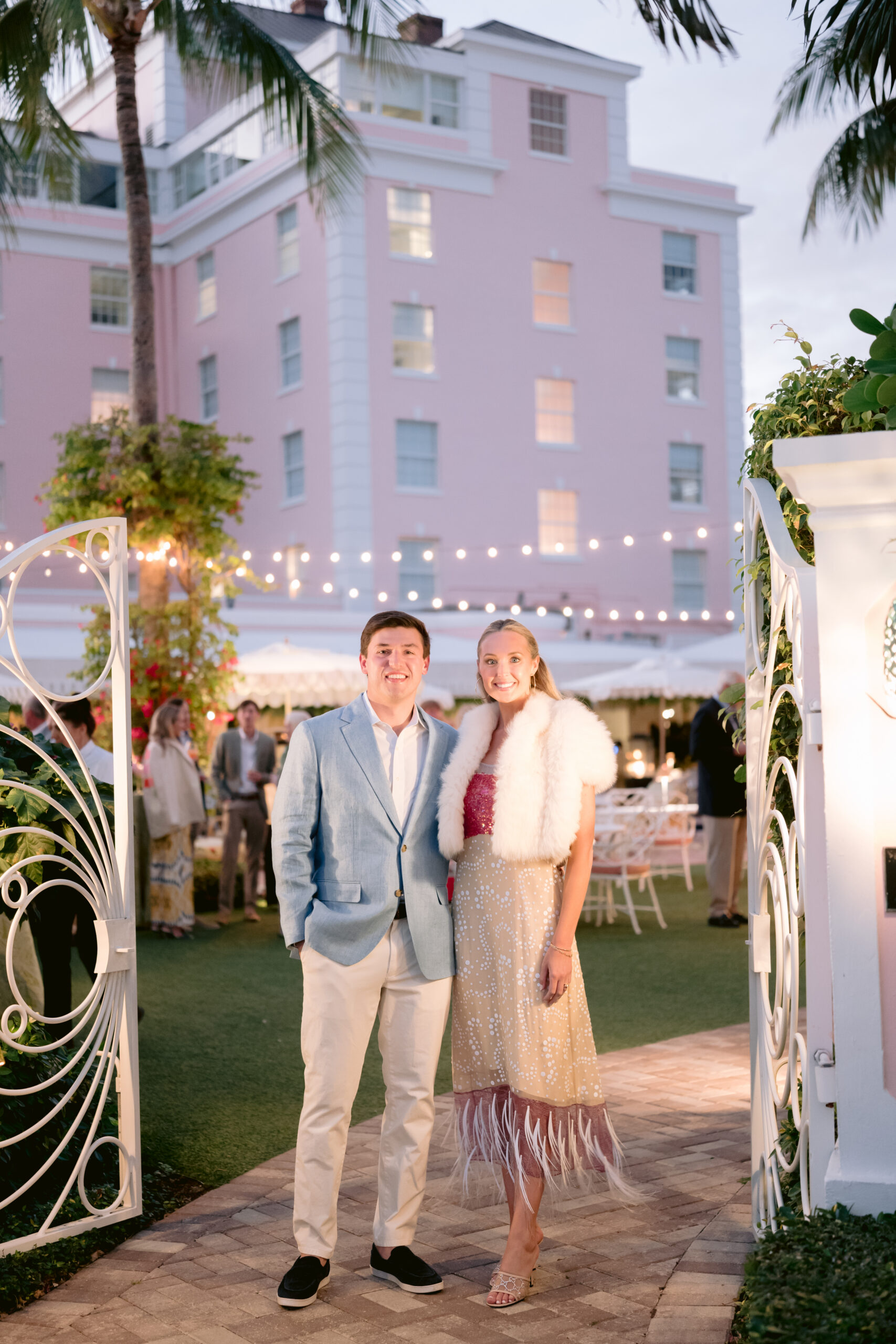 bride and groom standing at the entrance of their colony hotel outdoors welcome party