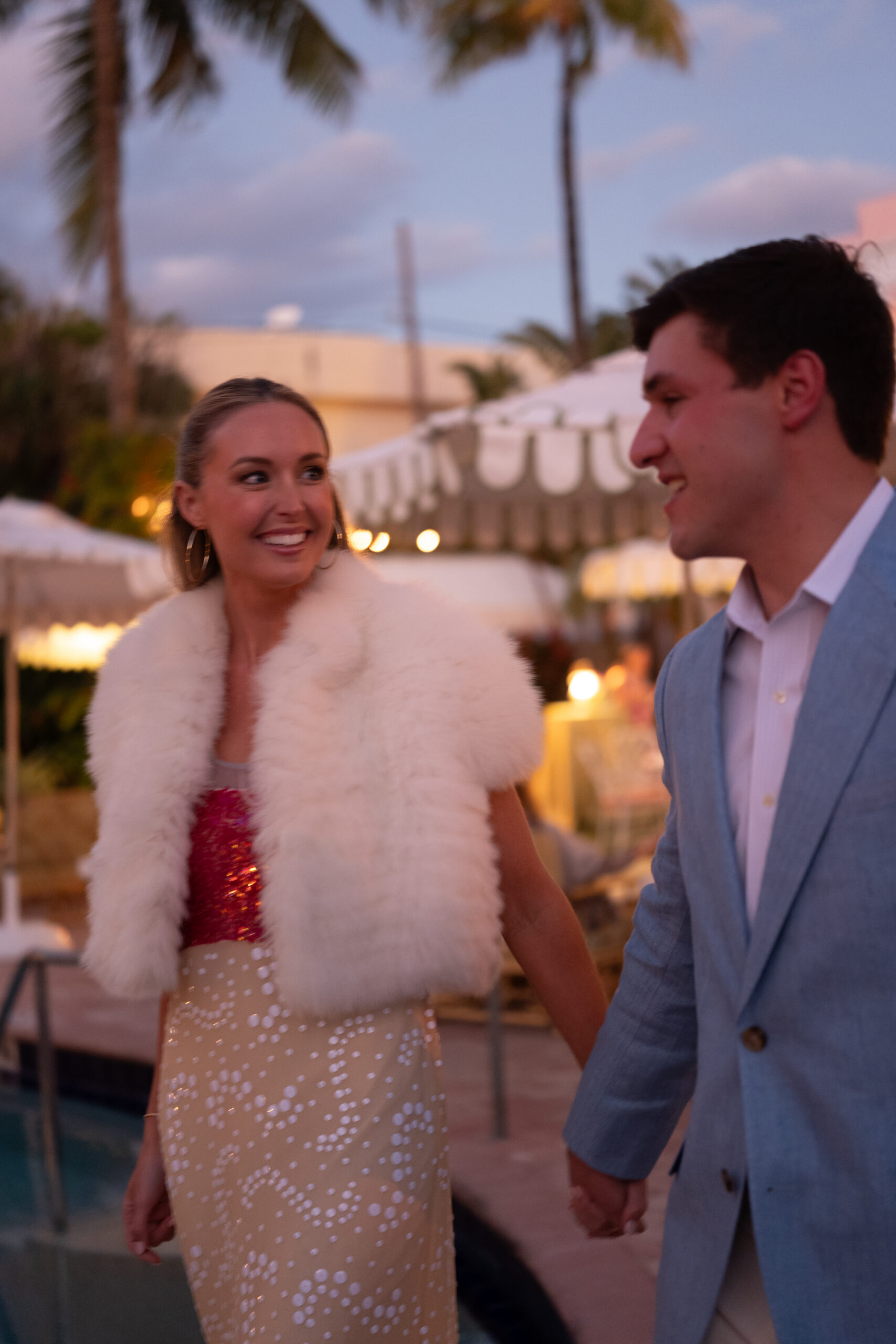 candid photograph of bride and groom smiling at each other while outdoors at their colony hotel and event venue welcome party