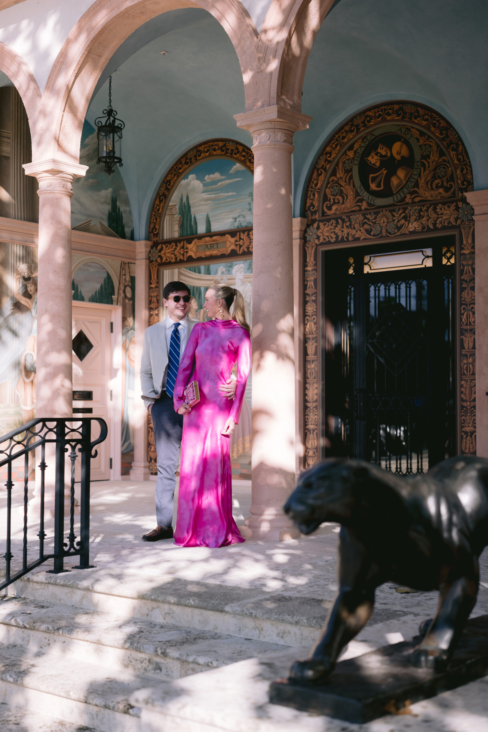 bride and groom standing beside the recognizable pillars at the colony hotel palm beach, fl event venue