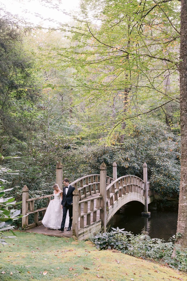 bride and groom hlding hands while walking off a wooden bridge during their half-mile farm portrait session