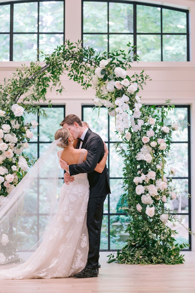 bride and groom kissing at the alter during their wedding ceremony at half-mile farm old edwards inn