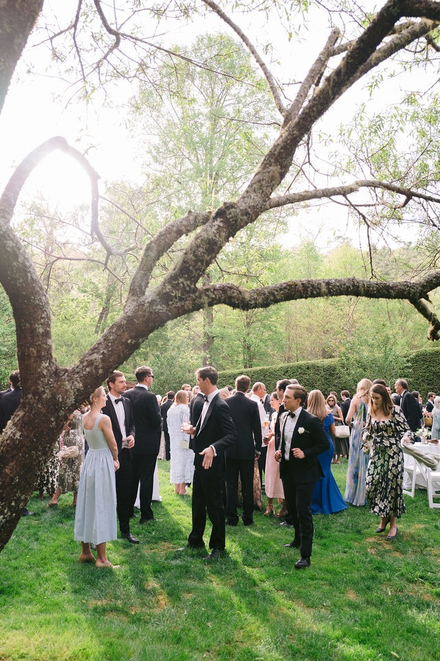 wedding guests gathered on the lawn of a highlands nc wedding venue during cocktail hour