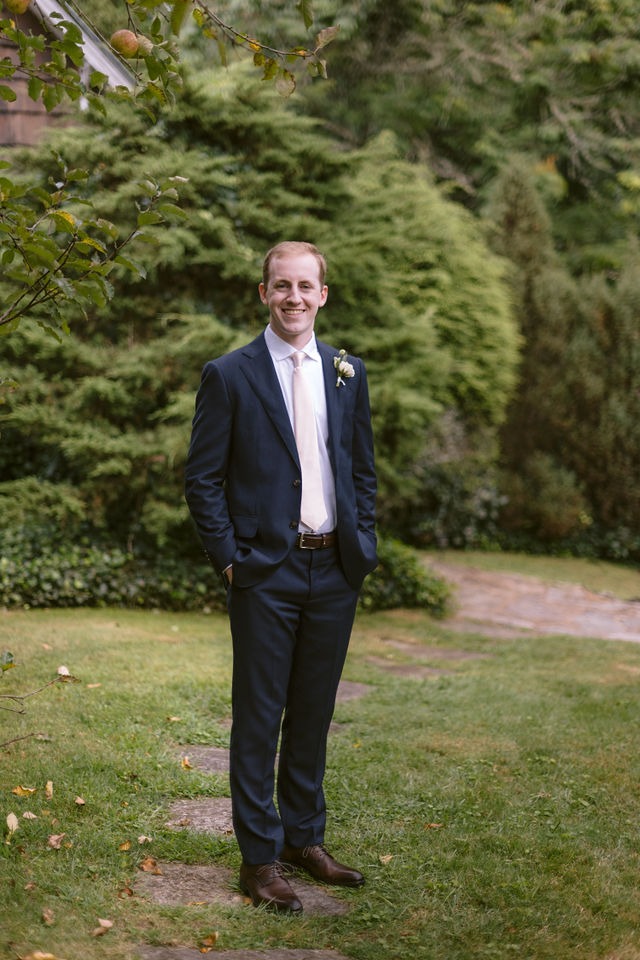 portrait of a groom standing on the lawn of a wedding venue in highlands nc