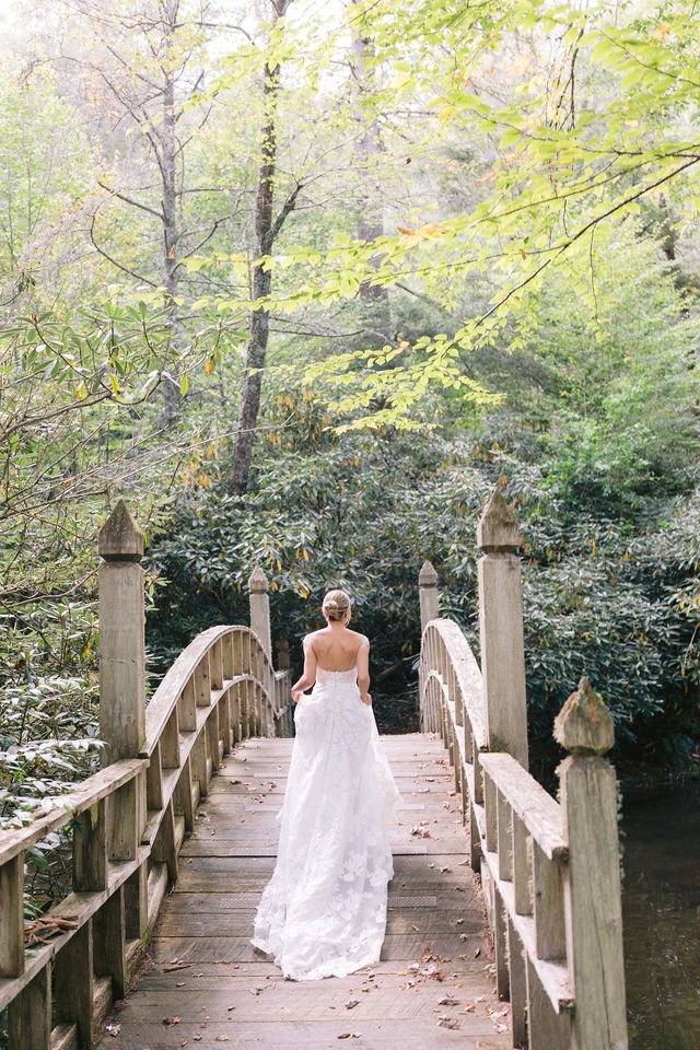 portrait of a bride walking away on a wooden bridge at one of the best highlands nc wedding venues