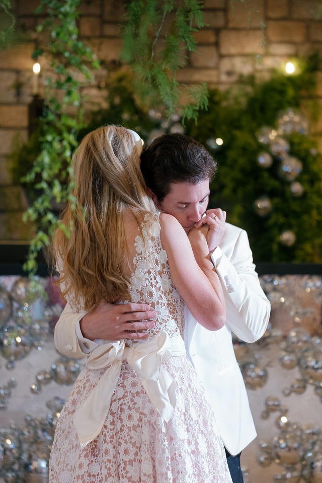 groom kissing his bride on her shoulder during their first dance at their old edwards half mile farm wedding