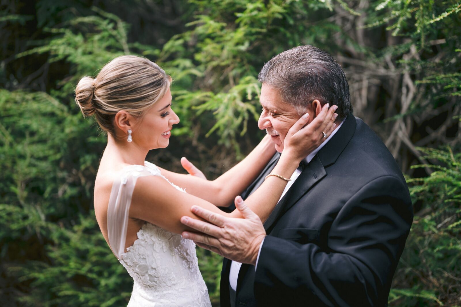 Bride sharing an emotional moment with her father outdoors on her wedding day.